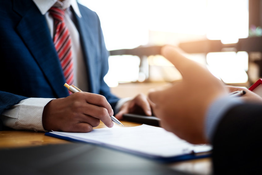 Ein Geschäftsmann unterzeichnet ein Dokument.